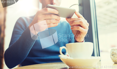 Image of close up of man with smartphones at cafe