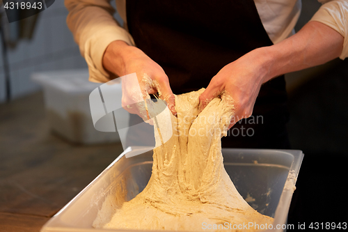 Image of chef or baker cooking dough at bakery