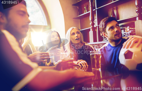 Image of fans or friends watching football at sport bar