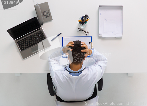 Image of doctor with cardiogram and laptop at clinic