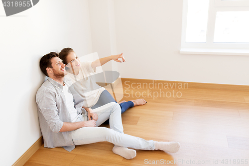 Image of happy couple at empty room of new home