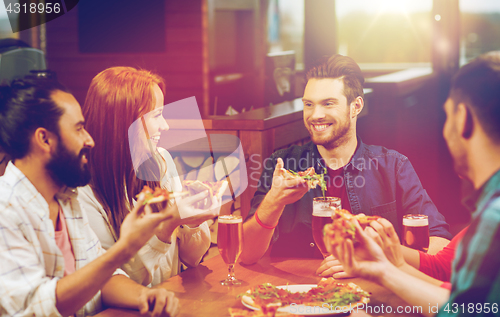 Image of friends eating pizza with beer at restaurant