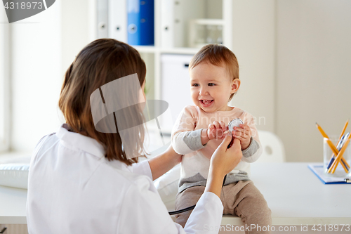 Image of happy doctor or pediatrician with baby at clinic