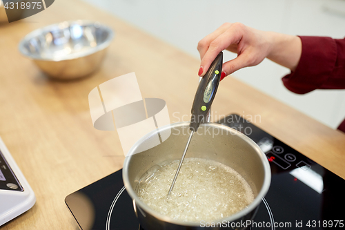 Image of chef measuring temperature in syrup at kitchen