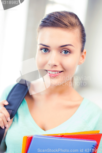 Image of student girl with school bag and color folders