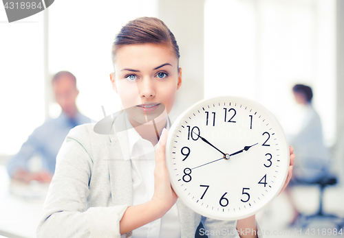 Image of businesswoman showing white clock in office