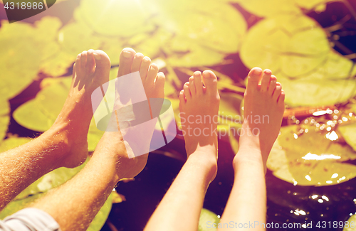 Image of grandfather and grandson feet over river