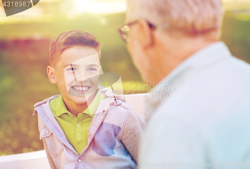 Image of grandfather and grandson talking at summer park