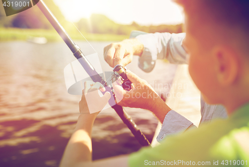 Image of boy and grandfather with fishing rod on river