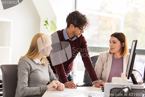 Image of happy business team with papers in office