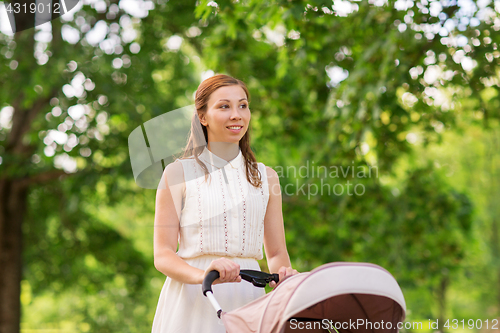 Image of happy mother with child in stroller at summer park