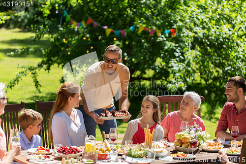 Image of happy family having dinner or summer garden party
