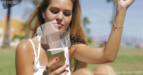 Image of Charming girl with phone and headphones