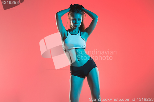 Image of Muscular young woman athlete posing at studio