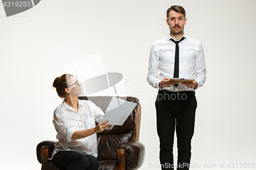 Image of The young man and beautiful woman in business suit at office on white background