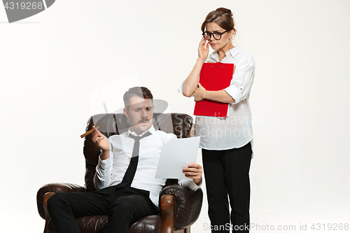 Image of The young man and beautiful woman in business suit at office on white background