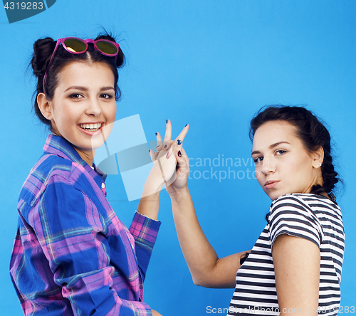 Image of best friends teenage school girls together having fun, posing emotional on blue background, besties happy smiling, lifestyle people concept 