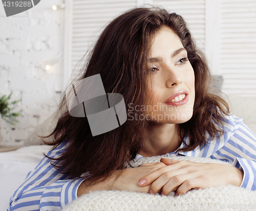 Image of young pretty brunette woman in her bedroom sitting at window, happy smiling lifestyle people concept 