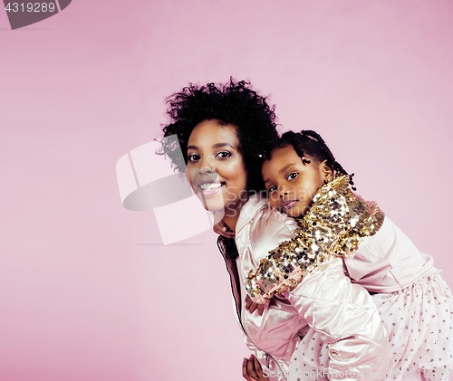 Image of young pretty african-american mother with little cute daughter hugging, happy smiling on pink background, lifestyle modern people concept 