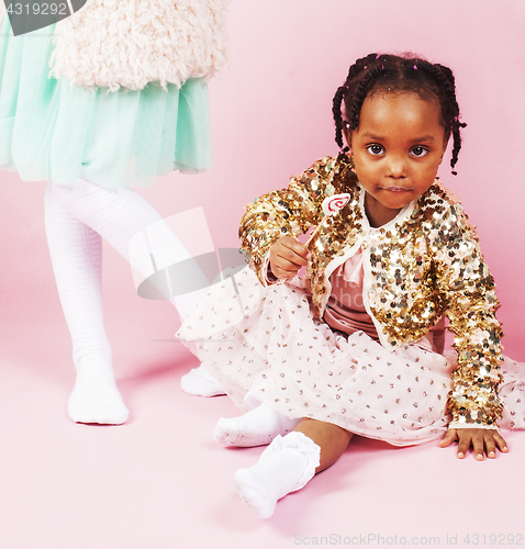 Image of lifestyle people concept: diverse nation children playing together, caucasian boy with african little girl holding candy happy smiling 