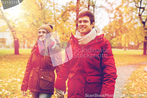 Image of happy young couple walking in autumn park