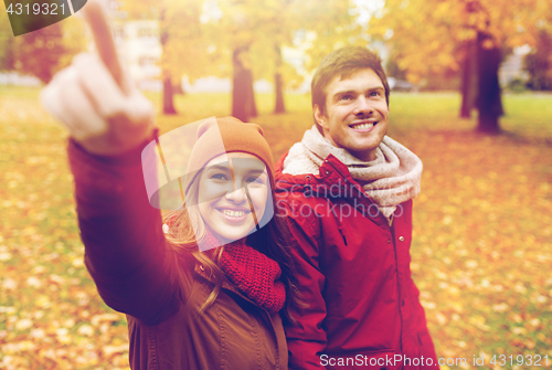 Image of happy young couple walking in autumn park