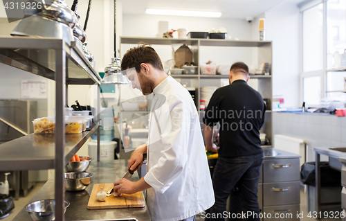 Image of chef and cook cooking food at restaurant kitchen