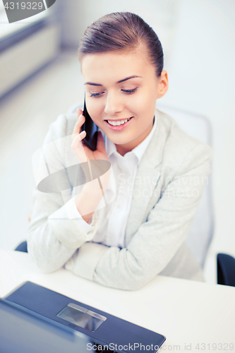 Image of businesswoman with smartphone in office