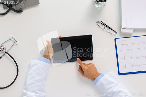 Image of doctor with tablet pc and cardiogram at clinic