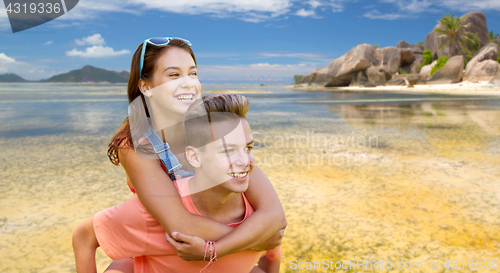 Image of happy teenage couple having fun on summer beach