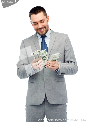 Image of smiling businessman counting american dollar money