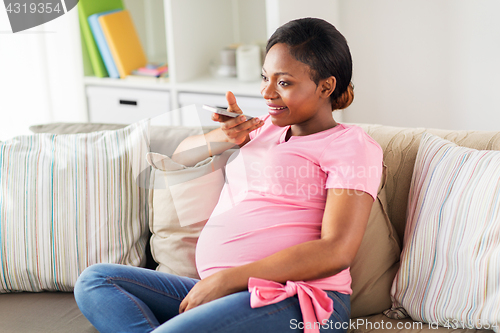 Image of pregnant woman using voice recorder on smartphone