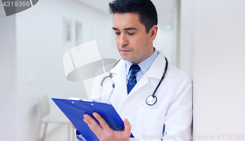 Image of doctor writing to clipboard at hospital