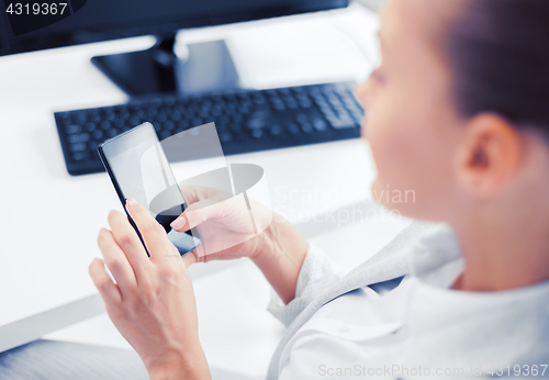 Image of businesswoman with smartphone in office