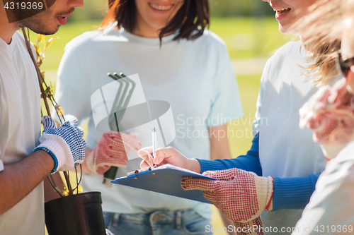 Image of volunteers with tree seedling and clipboard