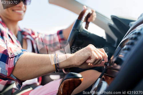 Image of happy young man driving convertible car