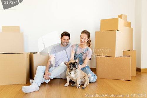 Image of happy couple with boxes and dog moving to new home