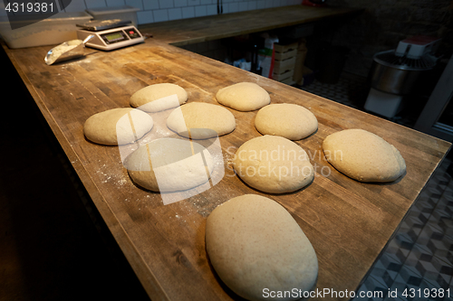 Image of yeast bread dough on bakery kitchen table