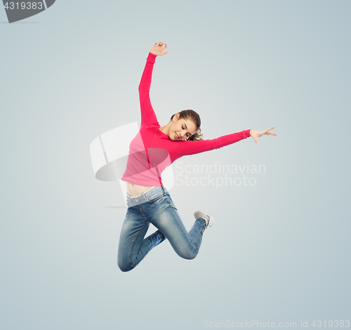 Image of happy young woman jumping in air or dancing