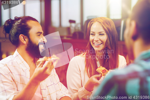 Image of friends eating pizza with beer at restaurant