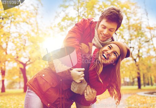 Image of happy young couple hugging in autumn park