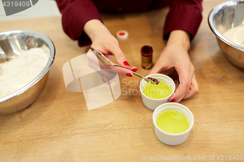 Image of chef adding food color into bowl with egg whites