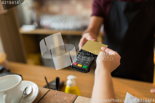 Image of hands with payment terminal and credit card