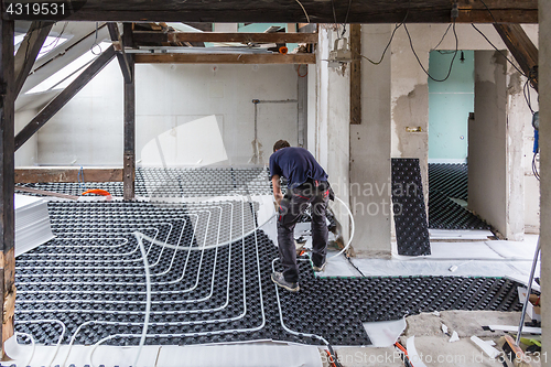 Image of Pipe fitter mounting underfloor heating.