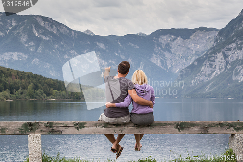 Image of Embraced couple watching tranquil overcast morning scene at lake Bohinj, Alps mountains, Slovenia.