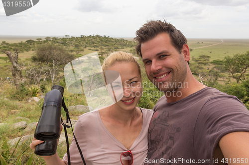 Image of Adult couple taking selfie on african wildlife safari in Serengeti national park, Tanzania, Africa.