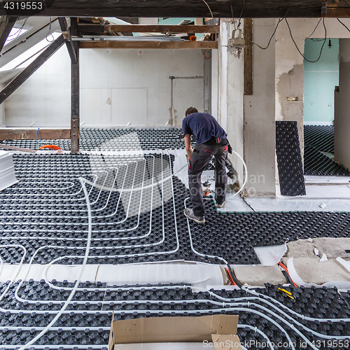 Image of Pipe fitter mounting underfloor heating.