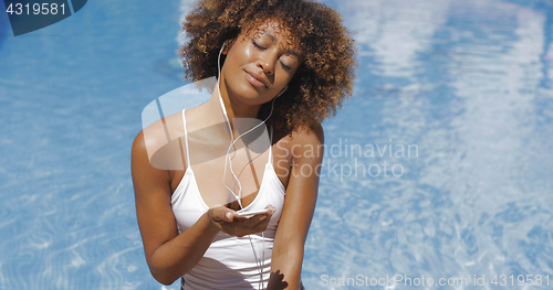 Image of Relaxing woman enjoying music in pool