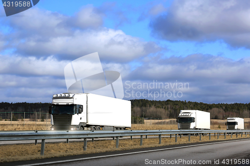 Image of Three White Semi Trucks Platoon on Freeway