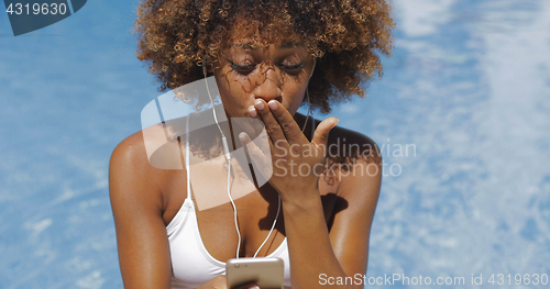 Image of Charming girl using phone in pool